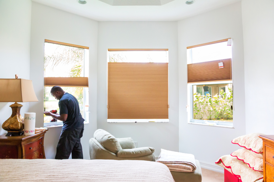 A man installing shades